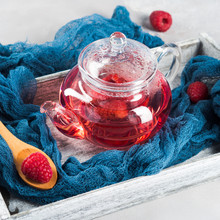 Raspberry Tea In Glass Teapot On Gray. Healthy Hot Drink
