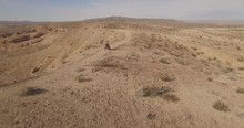 Close Aerial Tracking Shot Of A Man Riding His ATV On A Desert Mountain