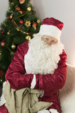 Fototapeta Do akwarium - Santa Claus with an empty bag. On the couch sat Santa Claus and examines an empty bag for gifts.