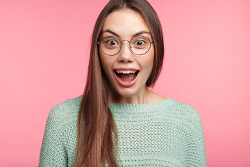 Wall Mural - Excited amazed young woman looks at fashionable clothes in shopping mall, doesn`t know what to buy, amazed with high discounts, wants to renew wardrobe. People, unexpectedness, excitement concept