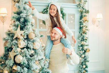 Dad and daughter decorate Christmas tree indoors. morning before Xmas