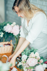 Wall Mural - Cute concentrated young female florist in glasses working in flower shop