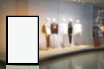 vertical advertising billboard or blank showcase light box for your text message or media content in front of men fashion clothes shop showcase in shopping mall, sale, commercial and marketing