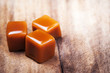 Homemade salted caramel pieces  on wooden  background. Golden Butterscotch toffee candy caramels with copyspace