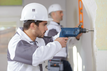 builders drilling the wall