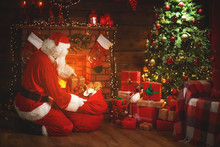 Merry Christmas! Santa Claus Near The Fireplace And Tree With Gifts