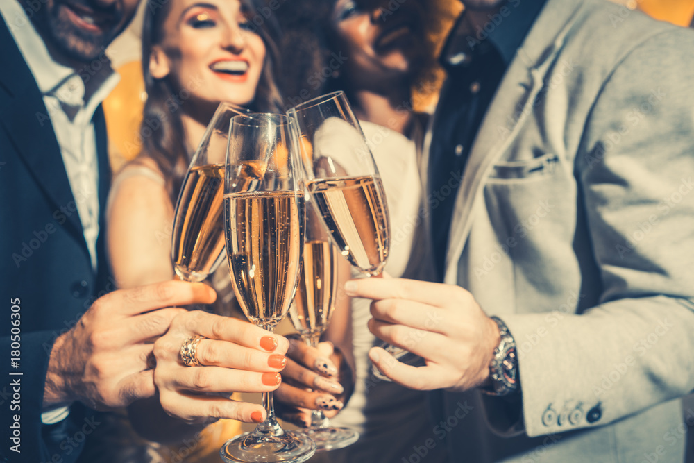 Men and women celebrating birthday or new years party while clinking glasses with sparkling wine - obrazy, fototapety, plakaty 