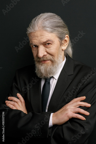 Stylish Elderly Man Stnding Against Black Wall With Crossed Hands