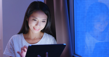 Wall Mural - Woman looking at tablet computer in the evening