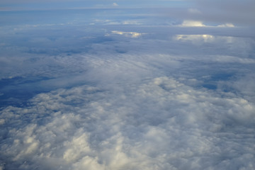 Wall Mural - view of beautiful abstract soft white cloud with shades of blue sky background from above flying pla