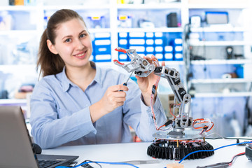 Wall Mural - A girl in a University laboratory is experimenting with a robot