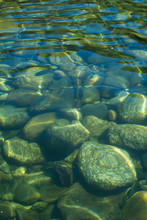 Close Up Of Green And Blue Background Of Pebbles And Stones Under Water 
