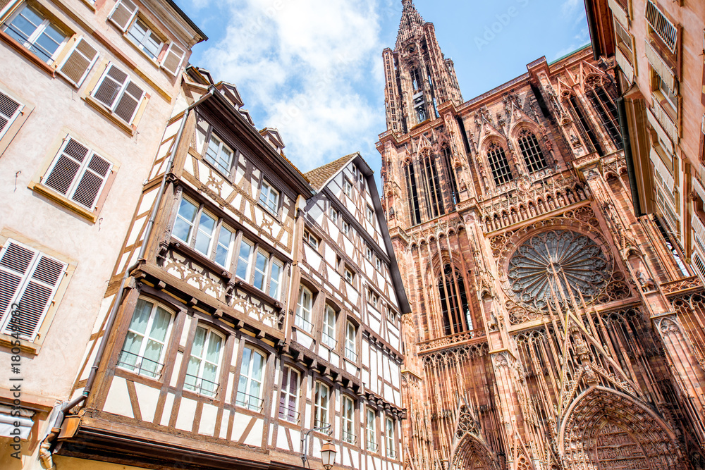 Street view from below on the beautiful old buildings and Notre-Dame cathedral in Strasbourg city, France - obrazy, fototapety, plakaty 
