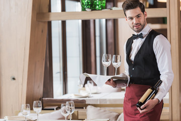 Wall Mural - Waiter holding wineglasses and bottle