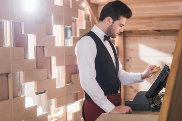 Wall Mural - Waiter standing at cash register