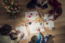 Top View Of A Family With Two Kids And A Baby Making Christmas Decorations