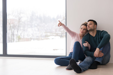 Wall Mural - young couple sitting on the floor near window at home