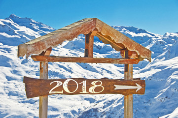 Wall Mural - 2018 written on a wooden direction sign, snow mountain landscape on the background