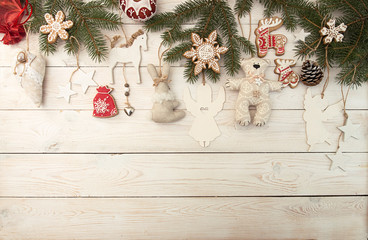 Overhead of Christmas New Year holiday background. Decoration with red gingerbread cookies, staffed toys, fir branch tree on white wooden background. Top view. Copy space