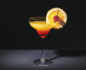 Canvas Print - Glass with tasty exotic cocktail on black background