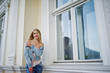 © AS Photo Family - Blonde girl wear on jeans posed against old house.