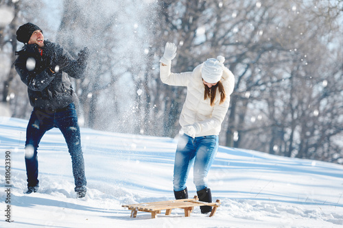 Couple snow fighting and having fun outdoors in winter - Buy this stock photo and explore similar images at Adobe Stock | Adobe Stock