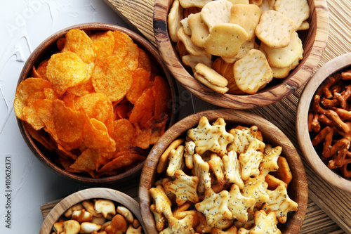 Cuadros en Lienzo Salty snacks. Pretzels, chips, crackers in wooden bowls.