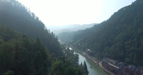Poster - Top view or aerial shot of famous ancient town in Fenghuang County, China. Flying over Green River, hills and houses of the village. Travel,destination and world heritage concept.