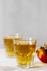 Apple juice in glasses and fresh apples on a wooden background. Rustic style.