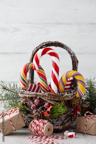Christmas Wicker Basket With Striped Candy Canes And Gifts On