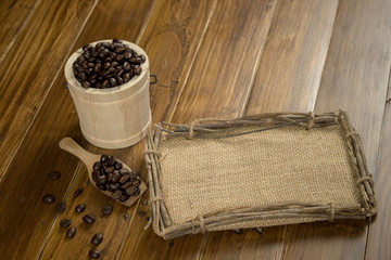 Wall Mural - Coffee bean grain and sack fabrice board on brown wood table background , include copyspace for add text or graphic in advertise or marketing content