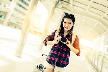 beautiful happiness young asian girl in casual dress traveling alone at train station or airport with backpack vintage tone photo concept