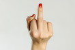 Female hand shows middle finger. Isolated on gray background. Closeup