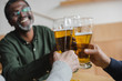 © LIGHTFIELD STUDIOS - man clinking glasses of beer with friends