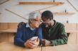 © LIGHTFIELD STUDIOS - Senior couple sitting indoors
