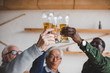 © LIGHTFIELD STUDIOS - senior friends clinking glasses of beer