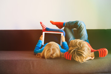 Wall Mural - little boy and girl looking at touch pad at home