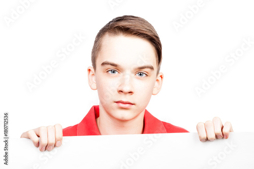 Fotografia, Obraz Teen boy holding blank banner or board on white emotionless