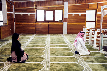 Two religious young people praying inside the mosque