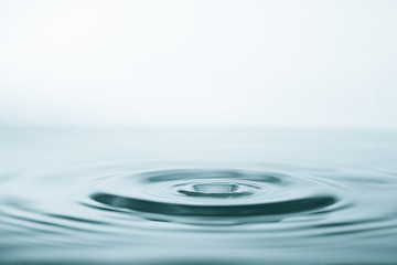 Wall Mural - water drop and splash on water surface on blue background