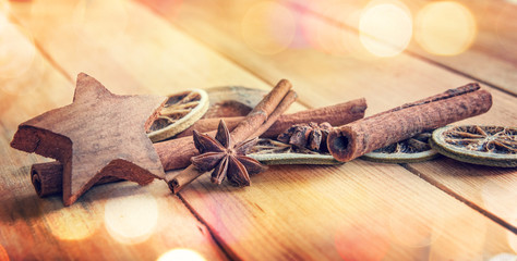 Sticker - Spices with dried orange and cinnamon on wooden background with blurred lights, christmas decor