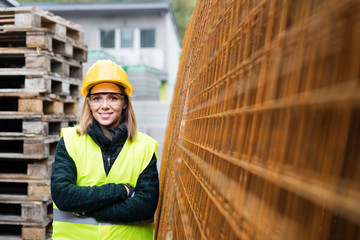 Poster - young woman worker in an industrial area.