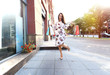 © opolja - Happy woman holding shopping bags and smiling at the mall