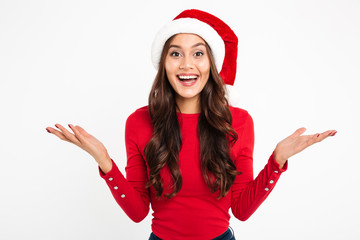 Poster - Excited young woman in christmas hat standing isolated