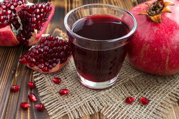 Wall Mural - Pomegranate juice in the glass on the wooden rustic background