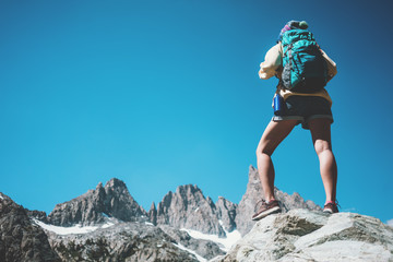 Wall Mural - Young woman backpacker looking at stunning mountain wild beauty