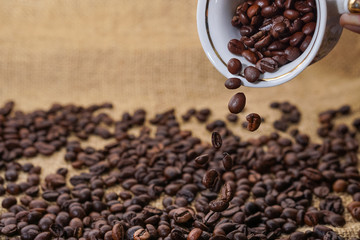 Wall Mural - Spilling out coffee beans from cup