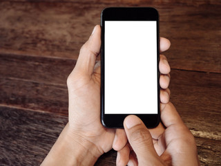 Poster - Closeup of man's hand is holding a black cell phone with blank white screen that you can put any ideas in this space on wood table at coffee cafe 