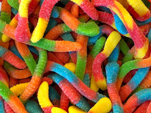 Sour Candy Gummy Worms Close Up Background. Covered In Granulated Sugar