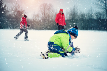 Wall Mural - Father with sons walking at snowfall